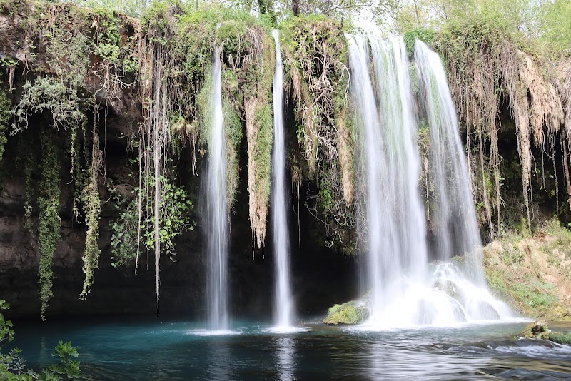 Silky long-exposure waterfall spilling over moss and hanging vines at Duden Falls, Turkey